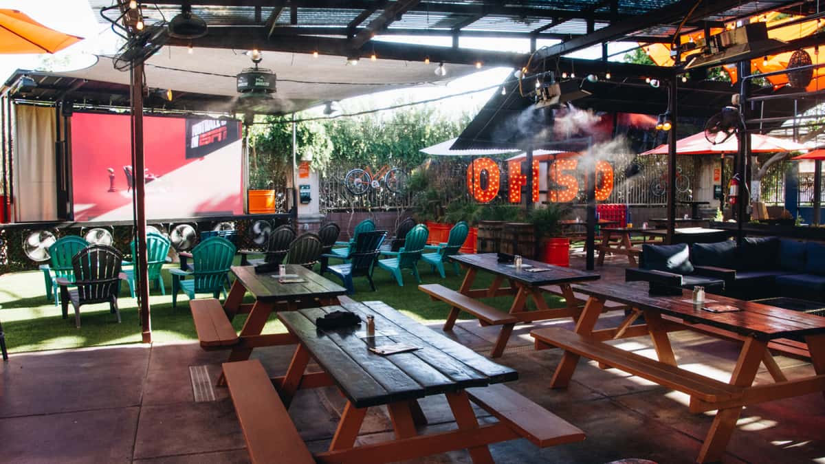 Large outdoor screen at O.H.S.O. Paradise Valley with lounge seating on the covered patio.