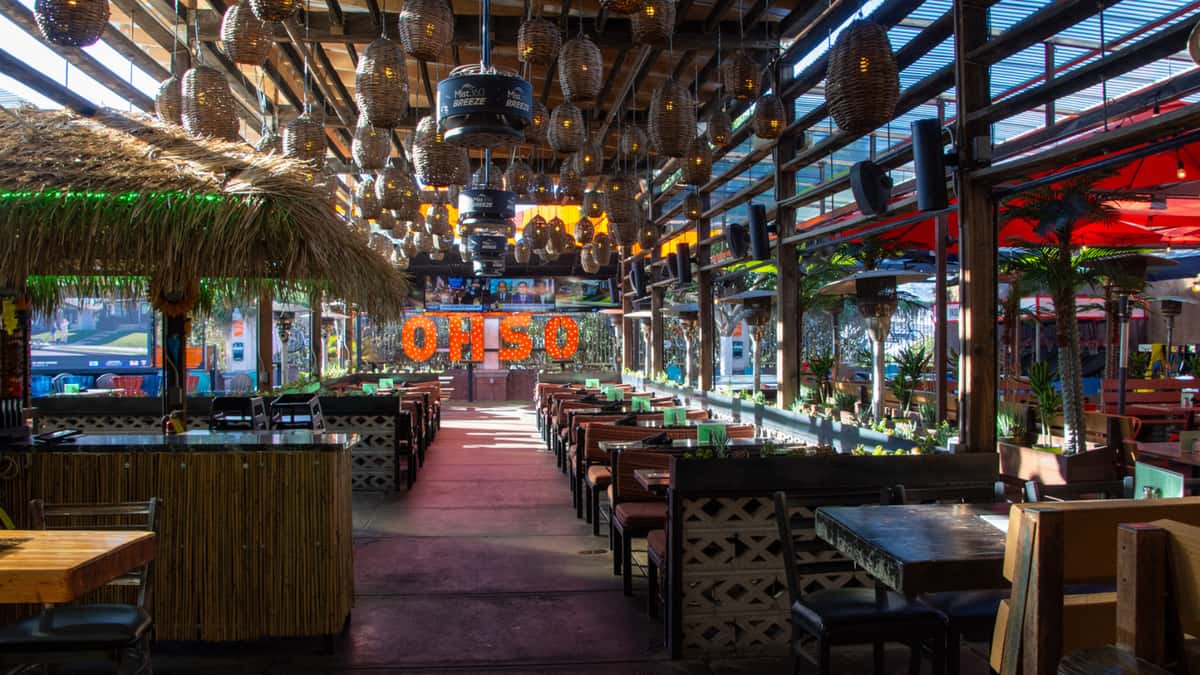 Full patio event space at O.H.S.O. Paradise Valley with covered dining areas, TVs, tiki bar, and access to the game zone.