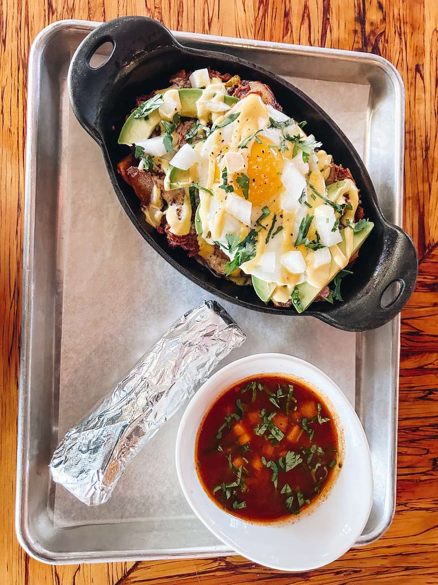 Hangover skillet birria hash with crispy potatoes, queso, avocado and sunny-side up eggs