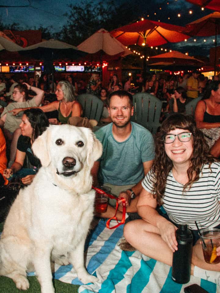 couple with dog at watch party at The Park at OHSO Brewery in Downtown Gilbert