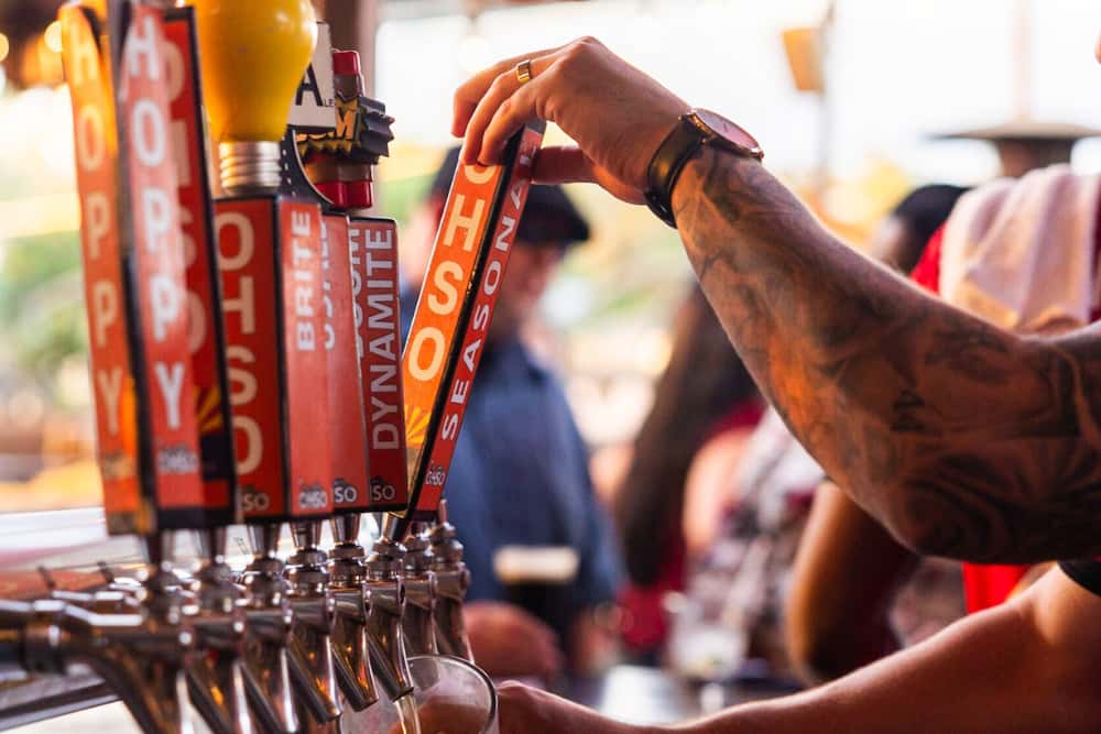A bartender pouring a beer from an OHSO tap handle