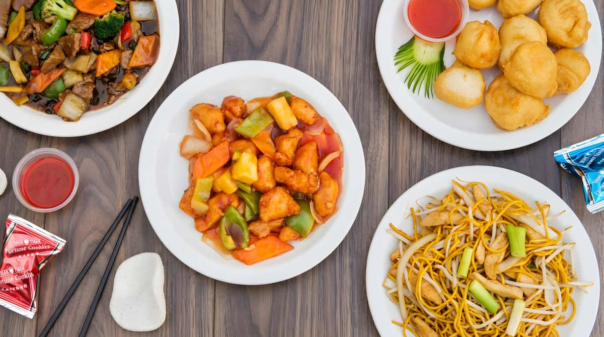 Assortment of Chinese dishes, including sweet and sour chicken, lo mein, beef with vegetables, and fried dumplings.