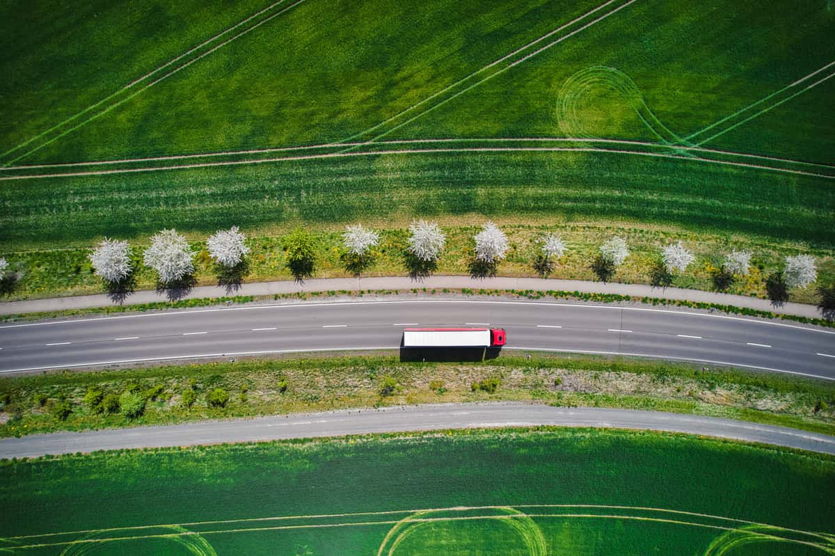 Aerial Shot of a truck driving next to fields.