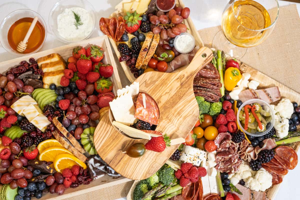 Charcuterie boards and cups, with dips and wine glasses.