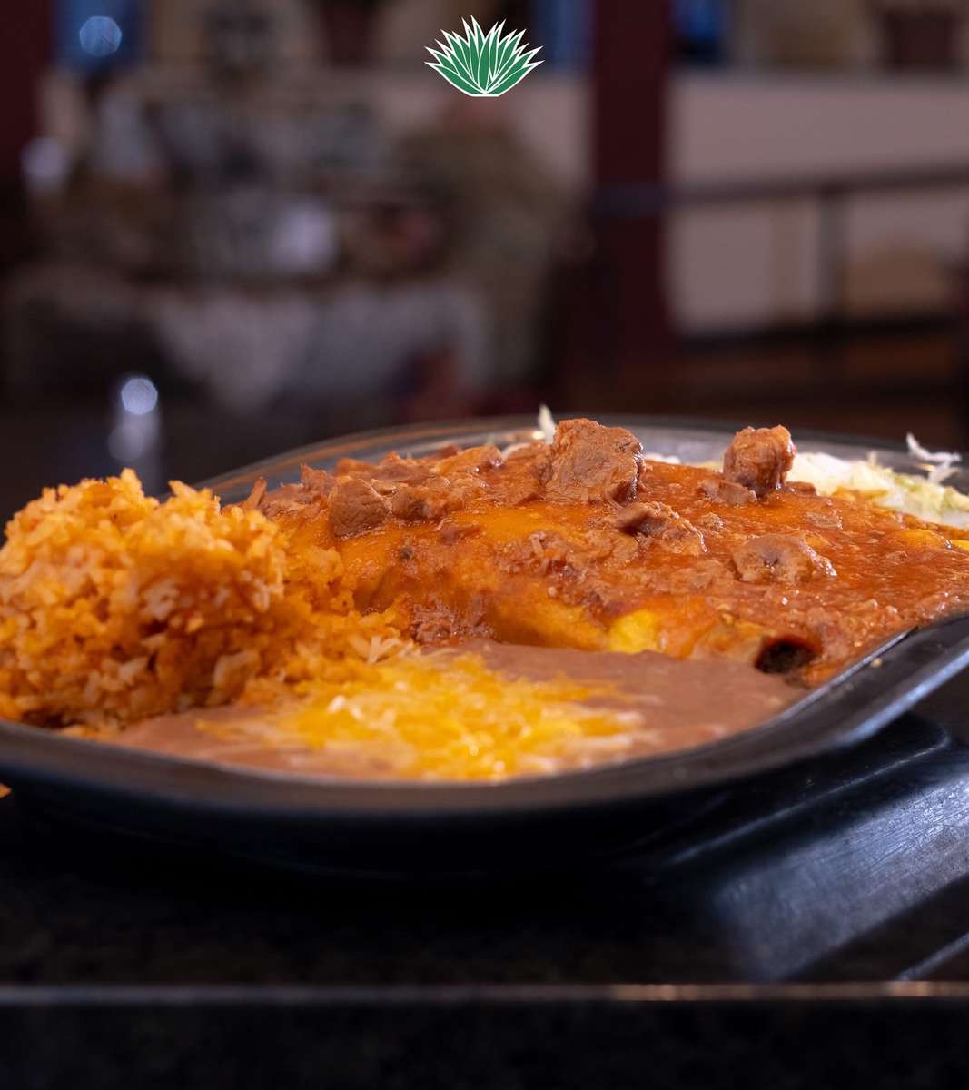 Cheese enchiladas covered in red sauce and served with Mexican rice