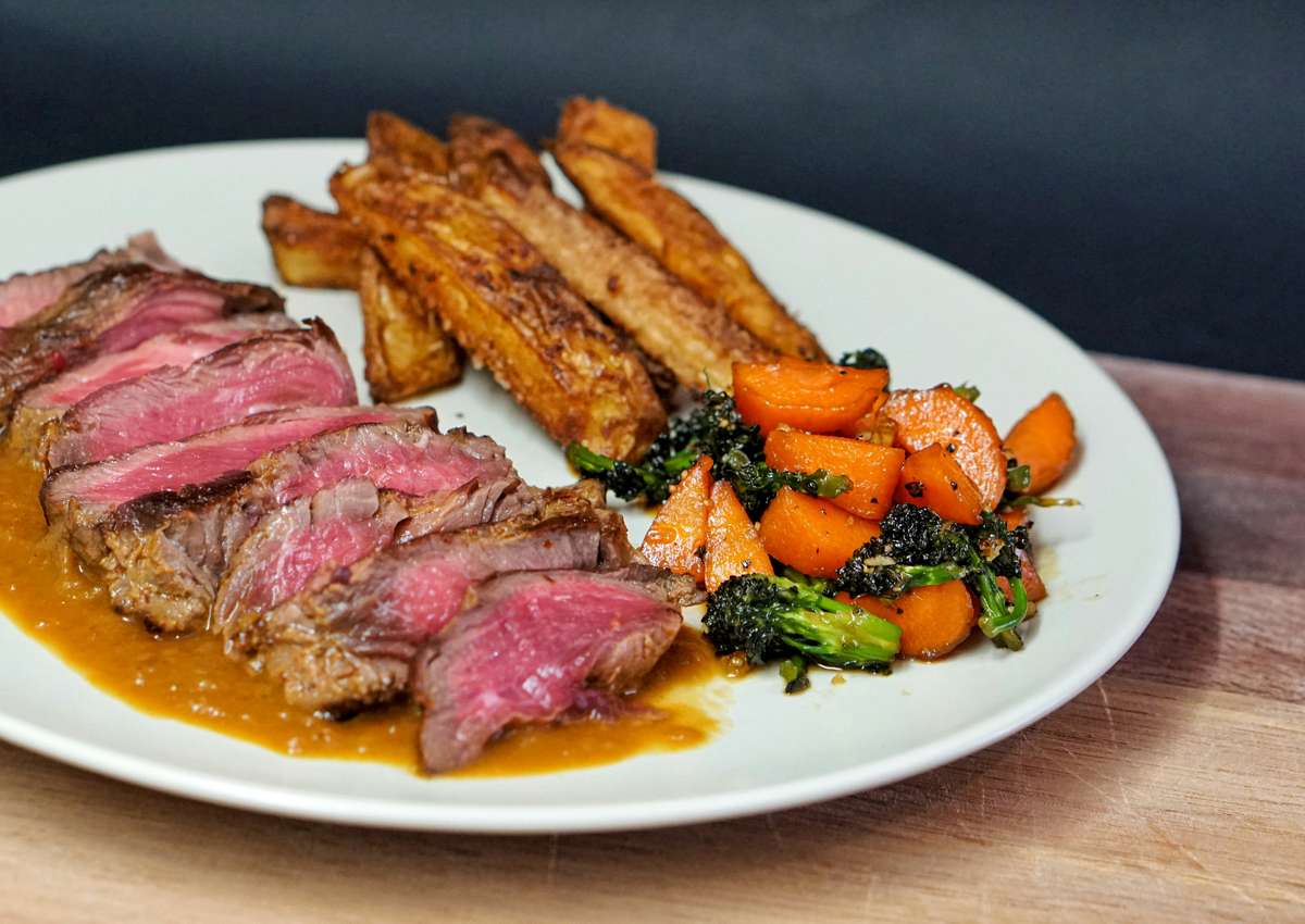 steak with sauce, veggies and sides