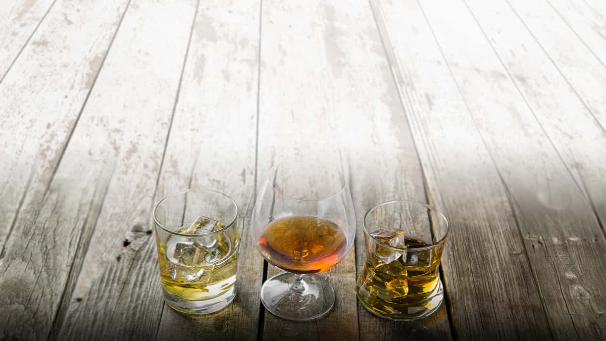 Glasses of tequila on wood background