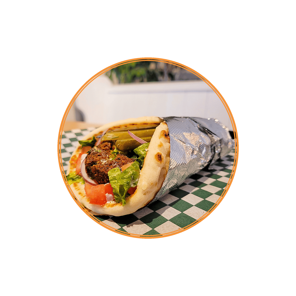 Crispy falafel wrap with lettuce, tomatoes, red onions, pickles, and tahini sauce wrapped in soft pita bread