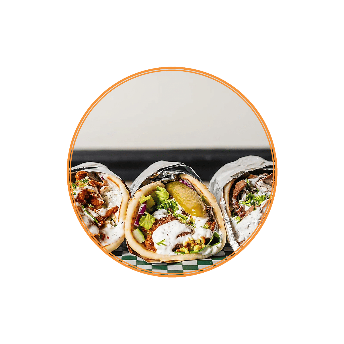Assorted gyro wraps filled with seasoned meat, fresh vegetables, pickles, and creamy garlic sauce in warm pita bread