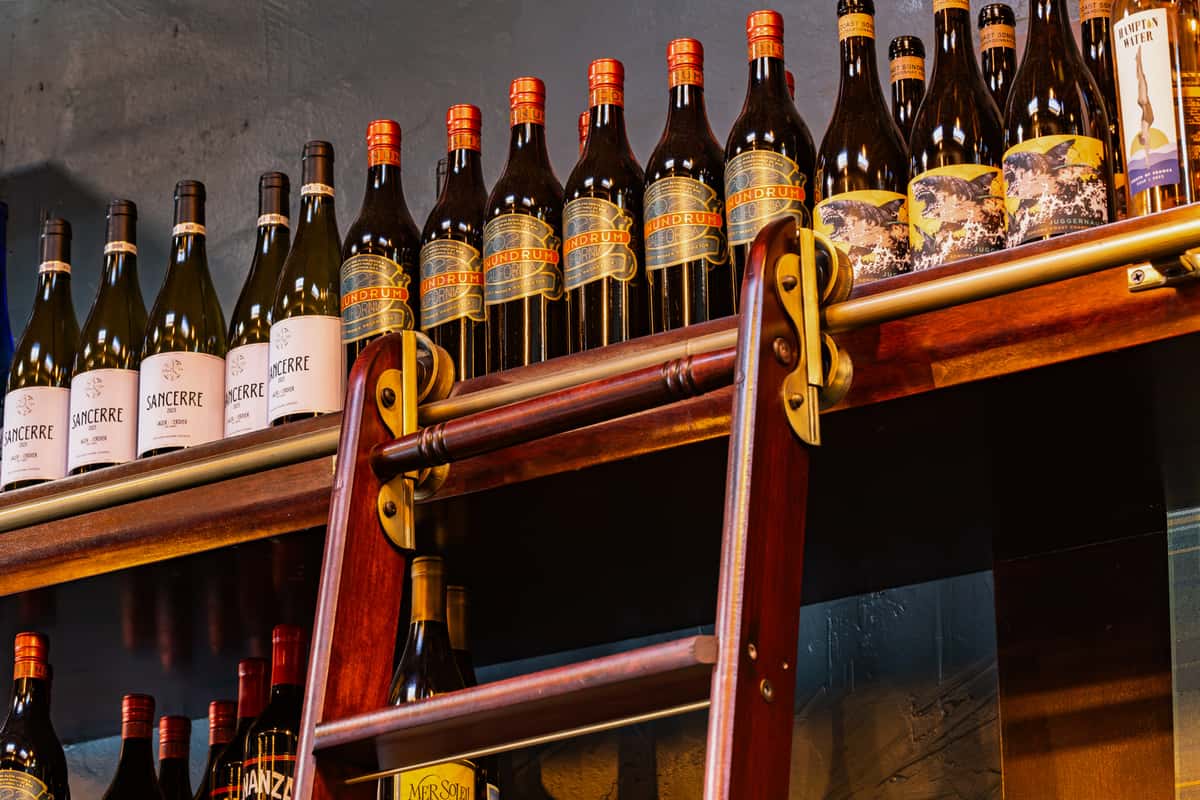 top shelf with bottles of wine