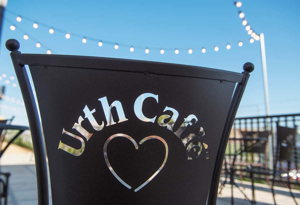 Back of an Urth Caffe metal chair silhouetted against blue sky 