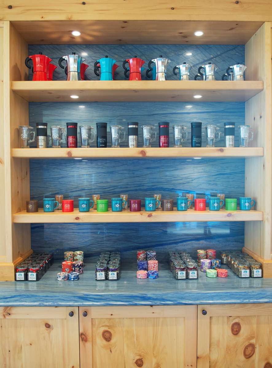 Shelves with travel mugs, tea canisters and glass cups