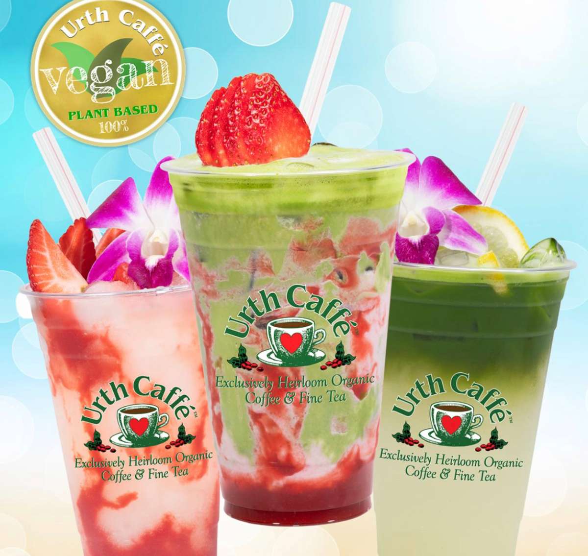 Trio of red strawberry and green matcha mixed vegan drinks with straws and garnished on topwith cut strawberries and orchids