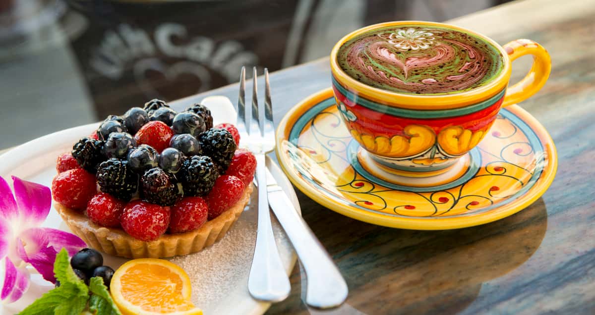 Fruit tart with hand painted ceramic cup and dish filled with Rising Sun Latté flower multi-colored art
