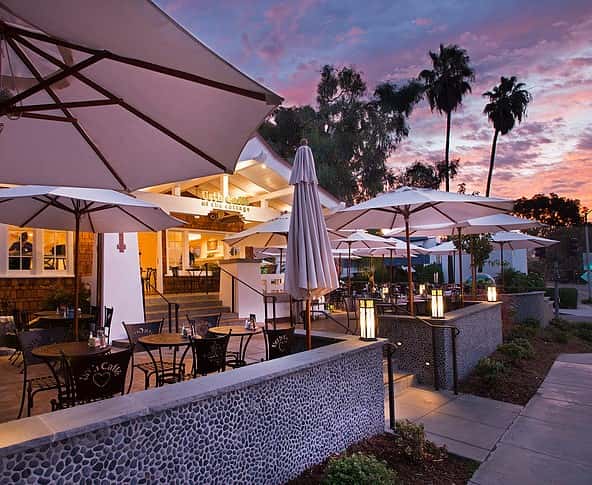 Sunset view of Urth Caffe Laguna Beach front porch and patio with tables and umbrellas