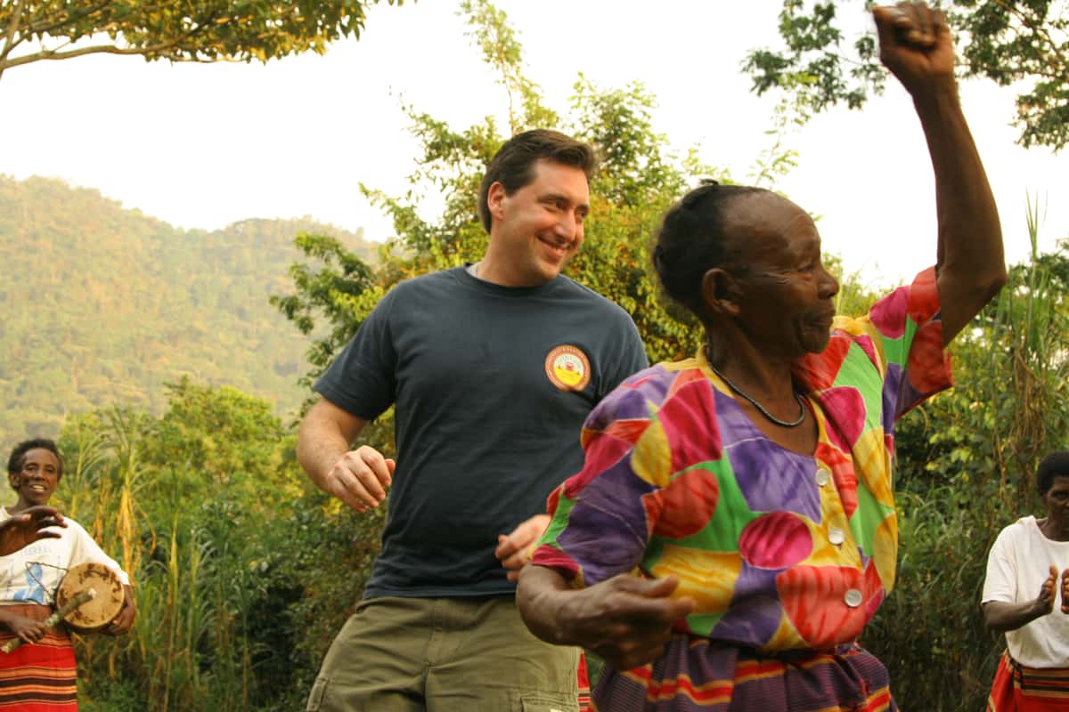 Shallom Berkman dancing with coffee farmers at Mountain Gorilla Coffee Estate