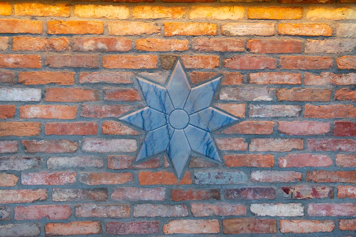 Blue marble seven-pointed star is embedded in a used brick wall