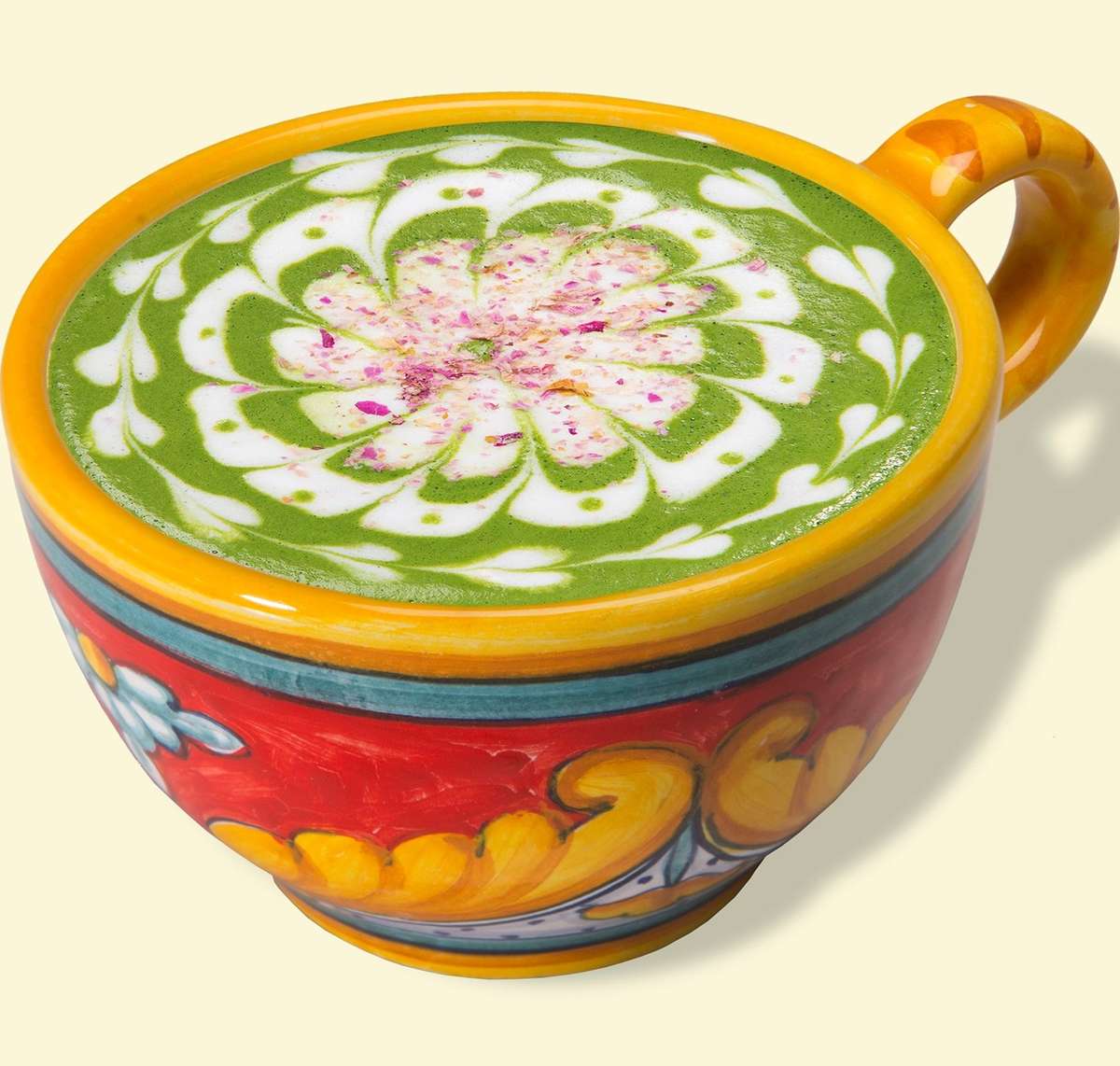 Green Rose Latte with green tea with white and pink design edged on top, in a floral mug