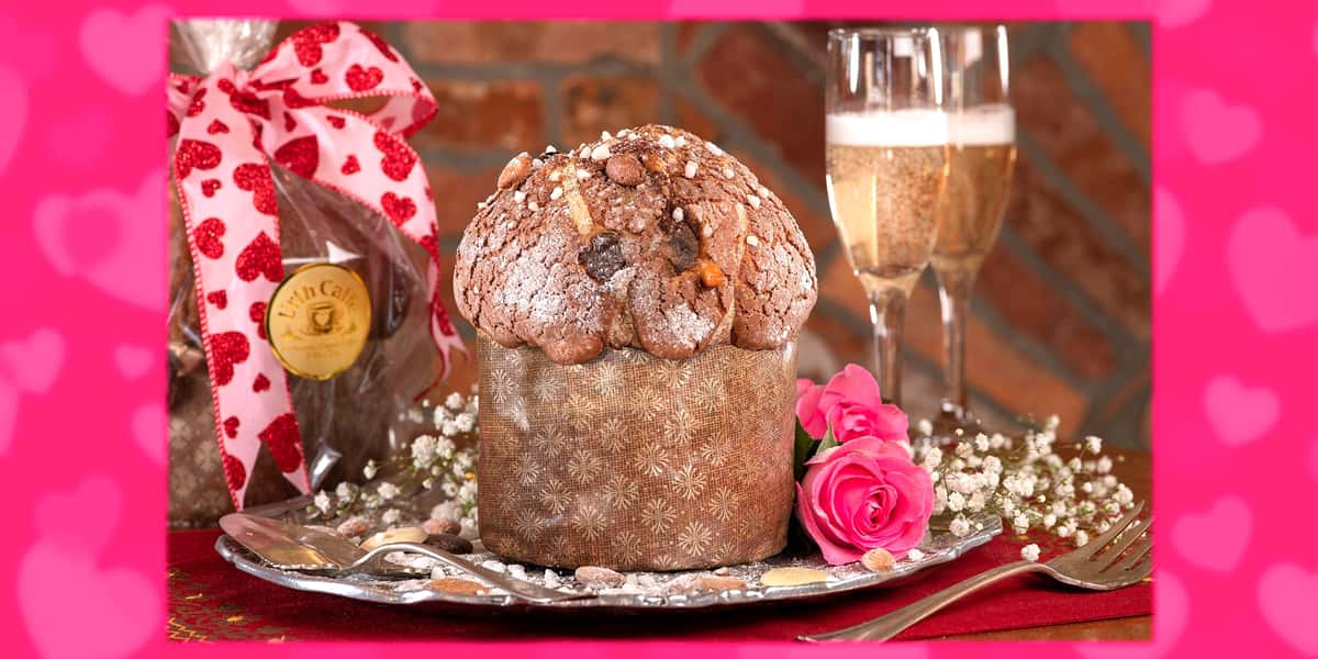 Valentine panettone with flowers, two glasses of champagne and a panettone wrapped in cellophane.