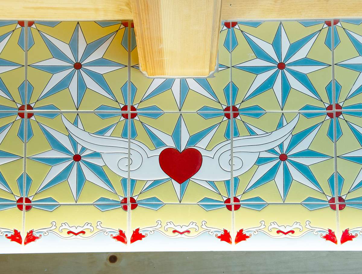 Tile motif shows a red heart with white wings with white, turquoise, light yellow, red accents.