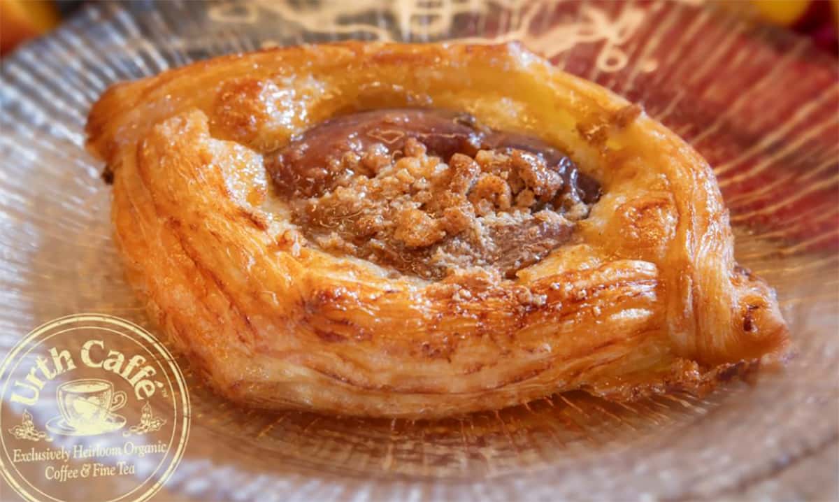 Urth's new Summer Peach Danish sitting on a clear glass plate with radiant ridges.