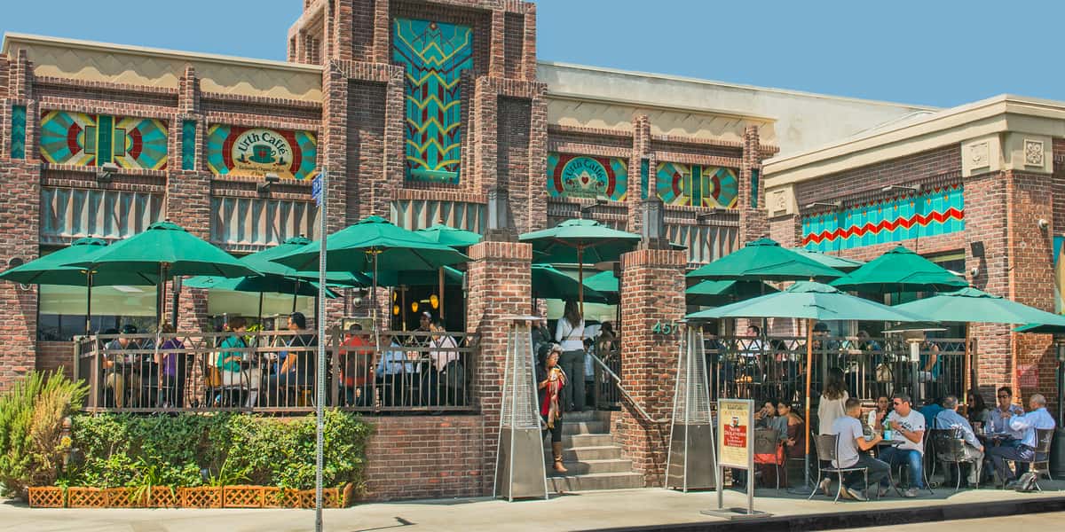 Urth Downtown facade with patios and street side tables full with patrons
