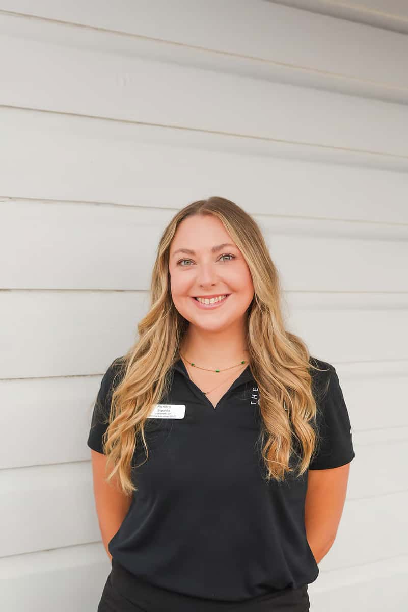 Portrait of a smiling Sandbar team member in a branded uniform, highlighting the welcoming staff and exceptional guest experience.