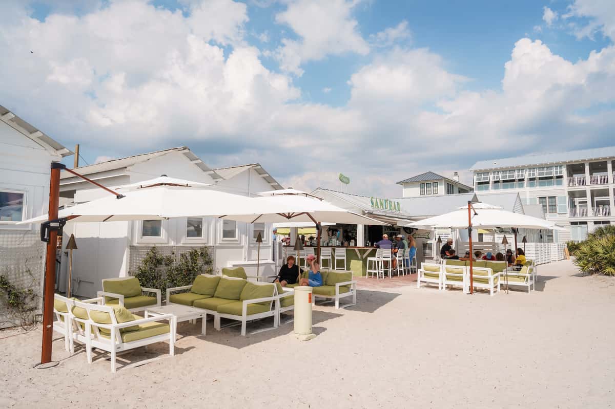 Spacious outdoor patio dining area with umbrellas and lounge seating at a waterfront restaurant.
