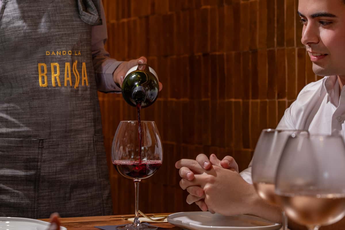A man serving a glass of wine