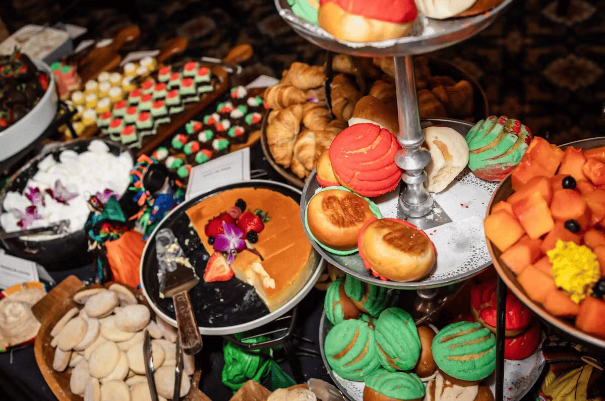 Colorful brunch dessert station featuring pastries, fresh fruit, cupcakes, and sweet treats at Hugo's restaurant buffet.
