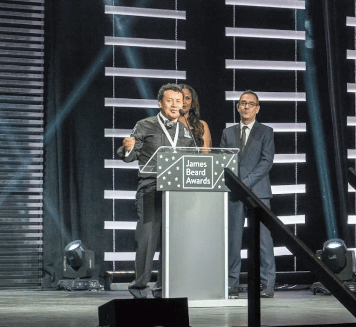 Chef Hugo accepting a James Beard Award on stage in recognition of culinary excellence.