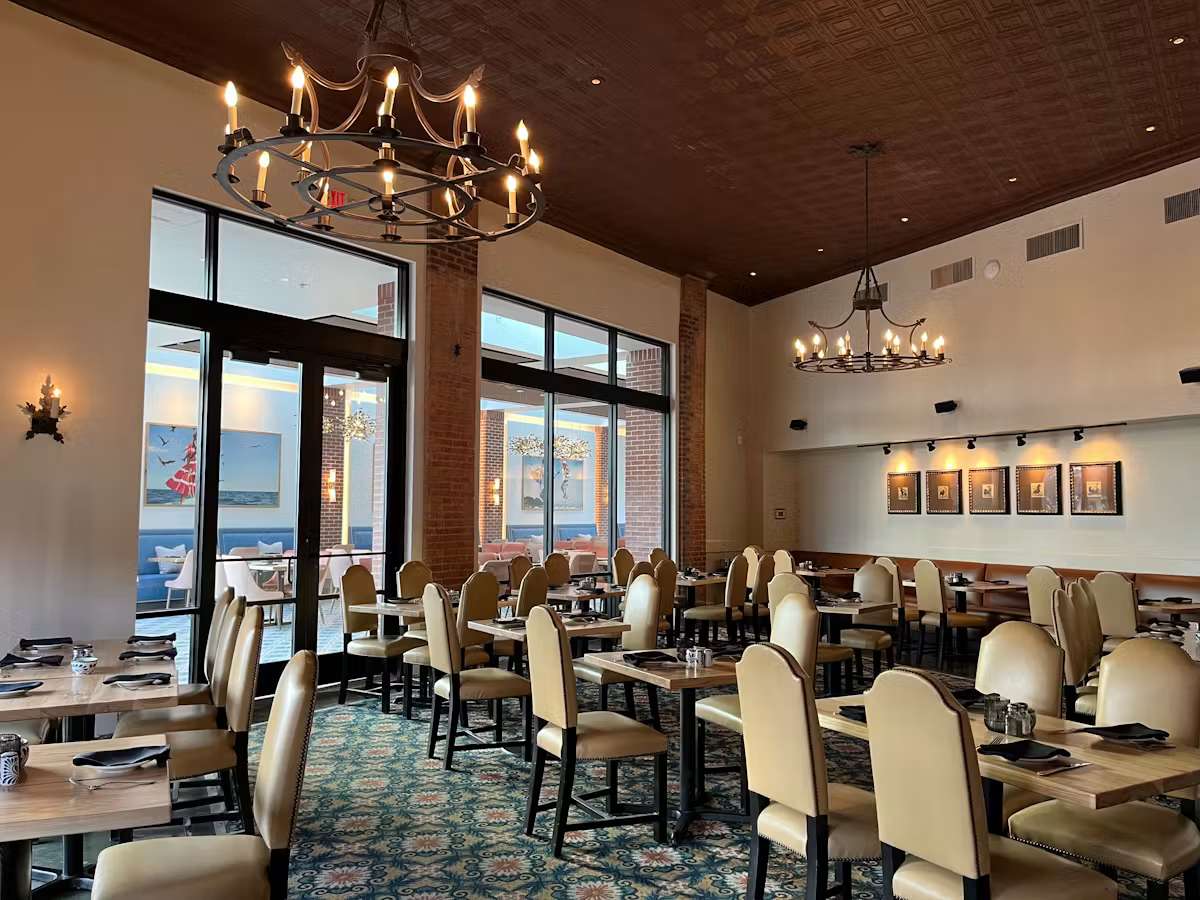 West Wing dining room at Hugo's restaurant featuring elegant seating, high ceilings, natural light, and a refined dining atmosphere.