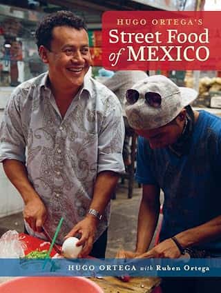 Hugo Ortega's Street Food of Mexico cookbook featuring Chef Hugo Ortega preparing authentic Mexican cuisine with a guest.