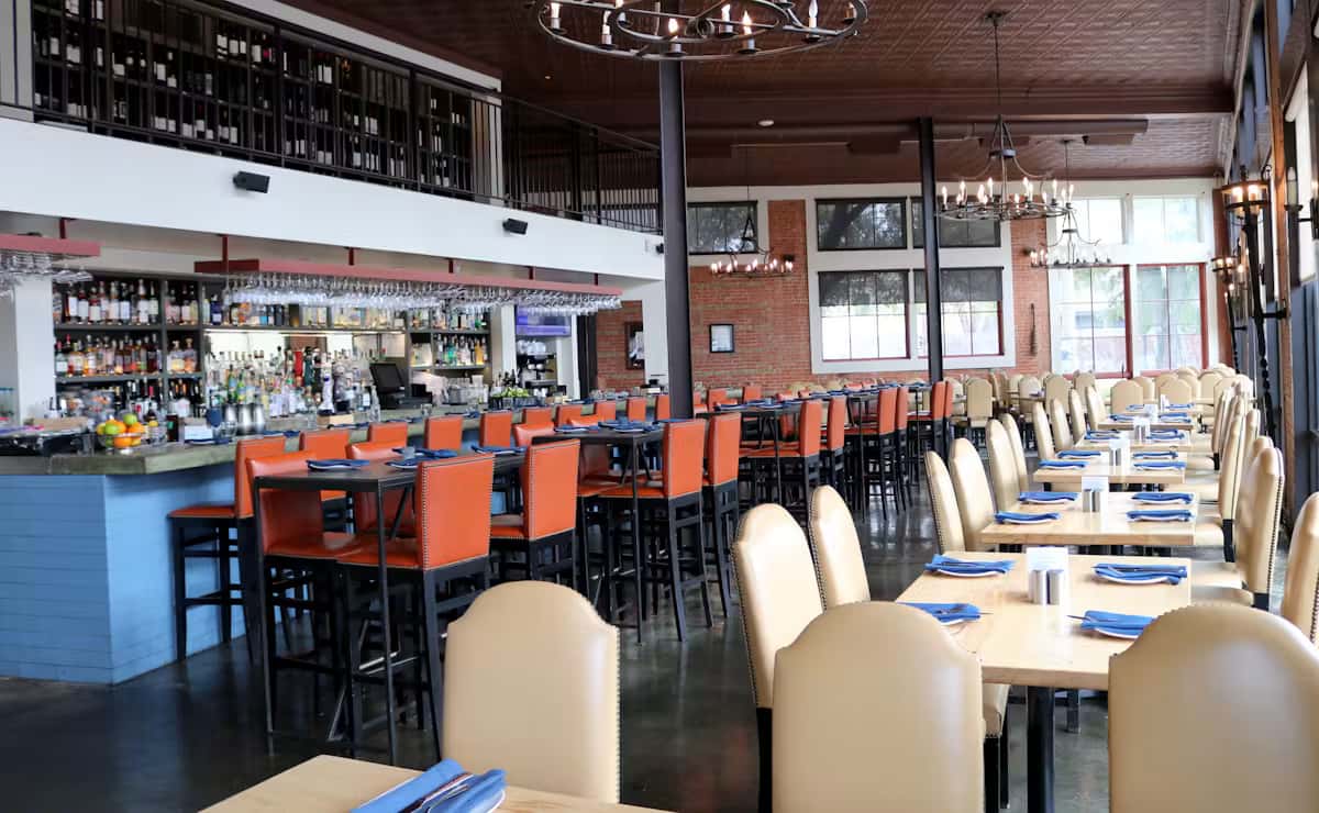 Modern dining room and bar at Hugo's restaurant with comfortable seating, full-service bar, and welcoming upscale ambiance.