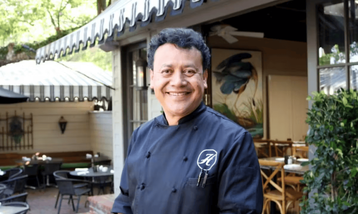 Chef Hugo smiling outside Hugo's restaurant, showcasing the welcoming hospitality behind the restaurant's cuisine.