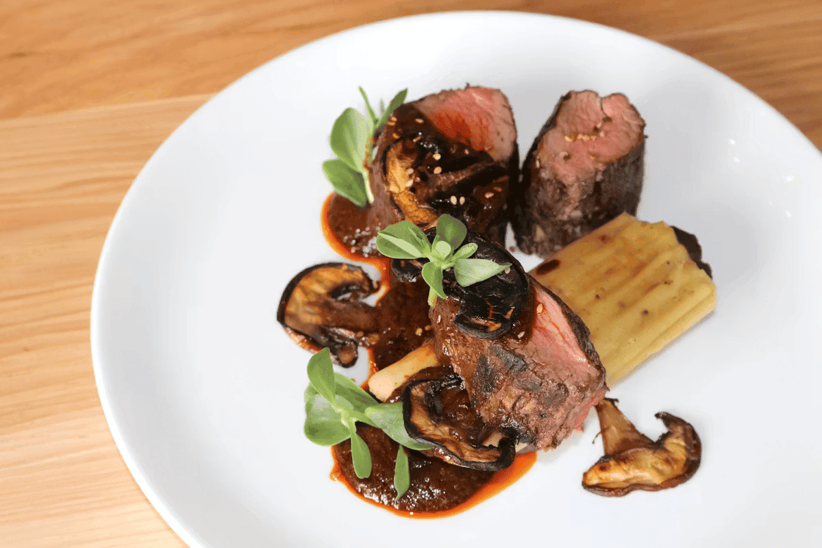 Oaxacan-style grilled filet with roasted vegetables, mushrooms, and traditional Mexican flavors at Hugo's restaurant.