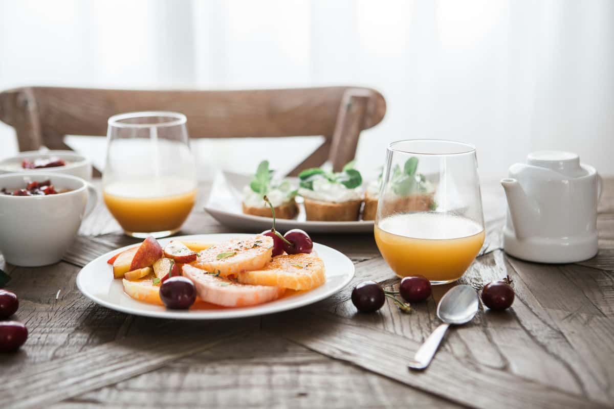 Photo of orange juice and breakfast foods on a table