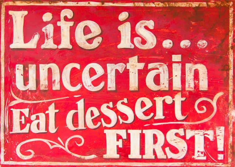 Writing on sign: Life is uncertain. Eat dessert first!