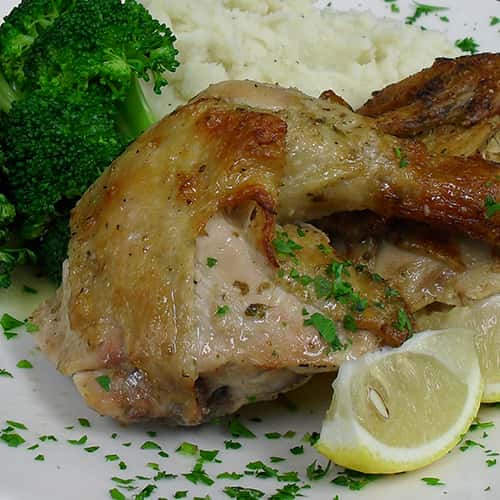 chicken with broccoli, mashed potatoes and a lemon wedge