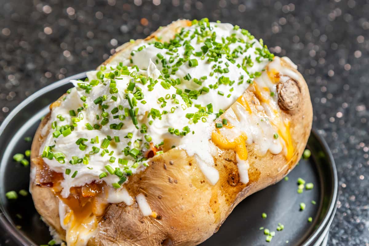 Classic loaded baked potato with sour cream, melted cheese, and fresh chives at Gorat's Steak House