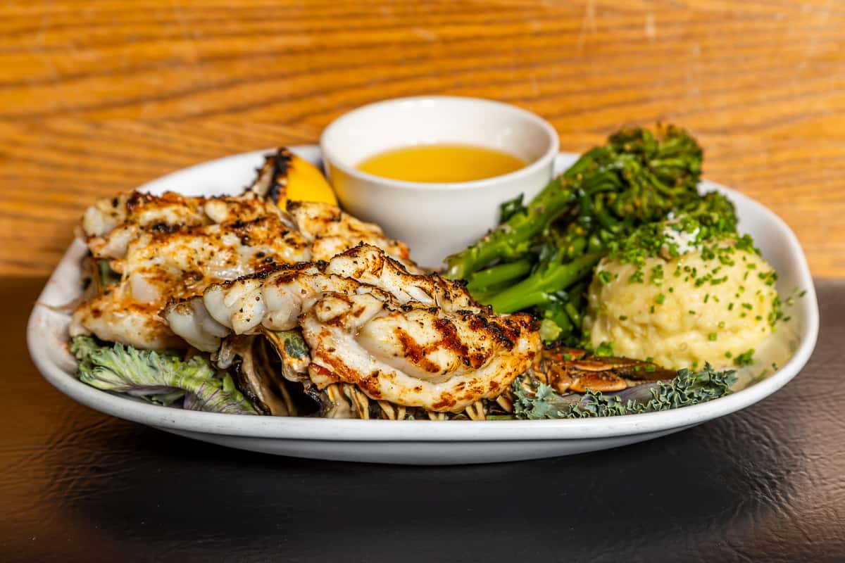 Lobster dinner with Yukon potatoes, broccolini, grilled lemon, and drawn butter at Gorat's Steak House
