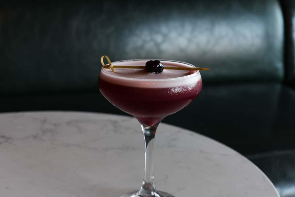 single drink on a table with a luxardo cherry