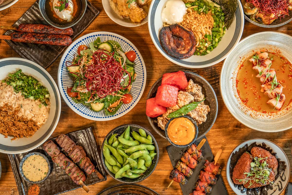 Hero image with spread of dishes on wooden table