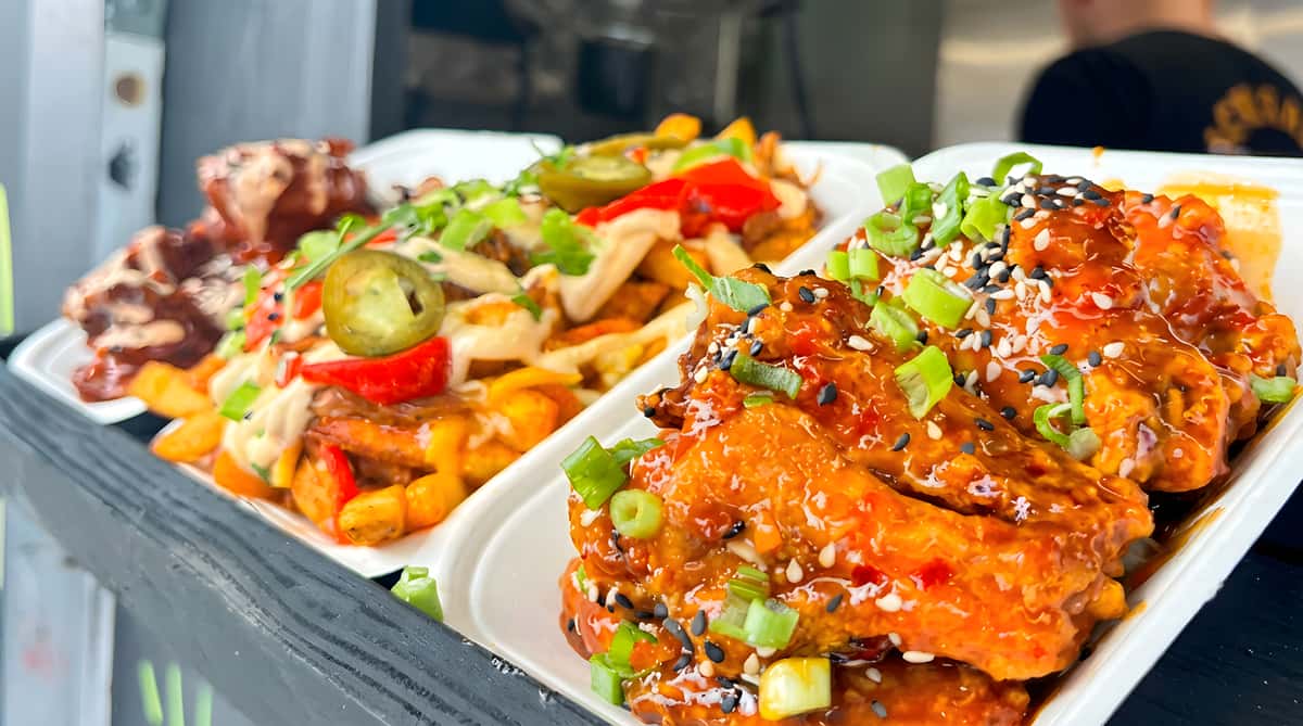Sweet chili glazed chicken wings served with loaded fries topped with vegetables and sauce