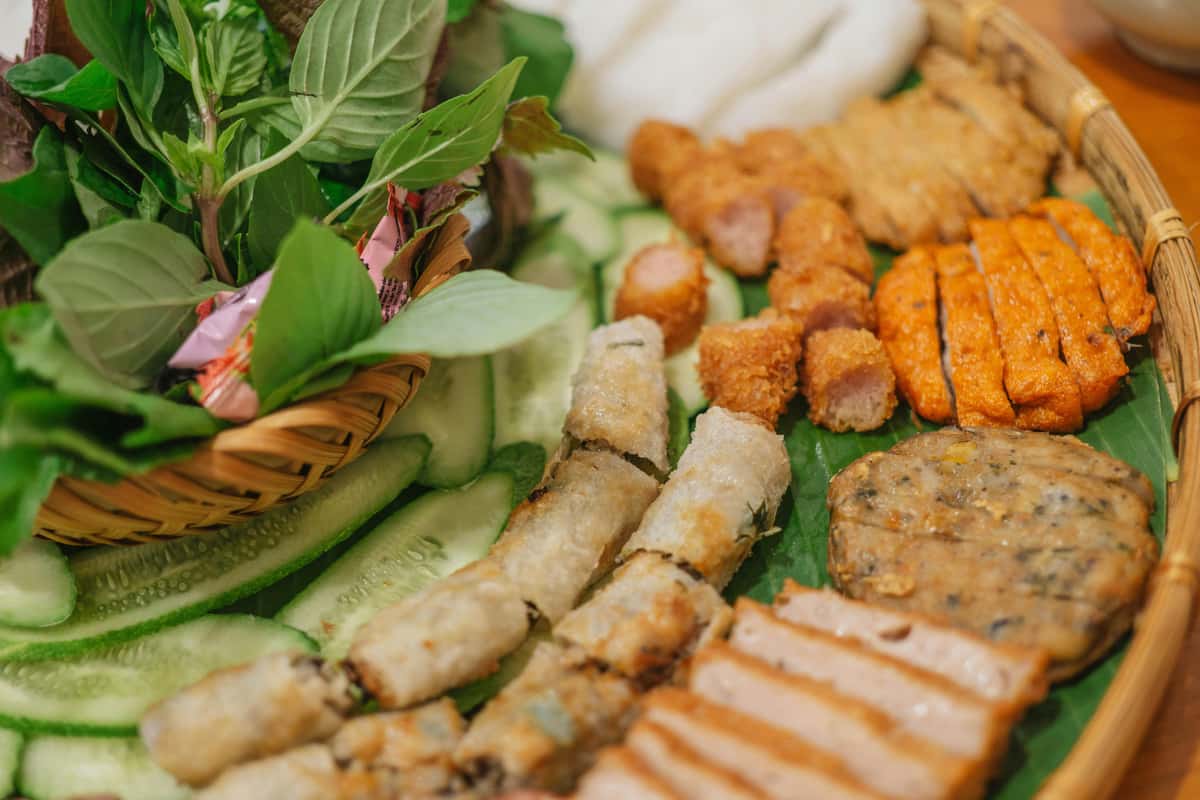 A Vietnamese appetizer platter with spring rolls, sliced pork, sausages, herbs, and cucumber at Pierce Creek.