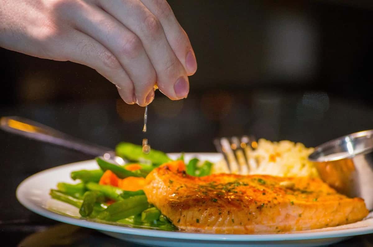 Squeezing lemon on salmon