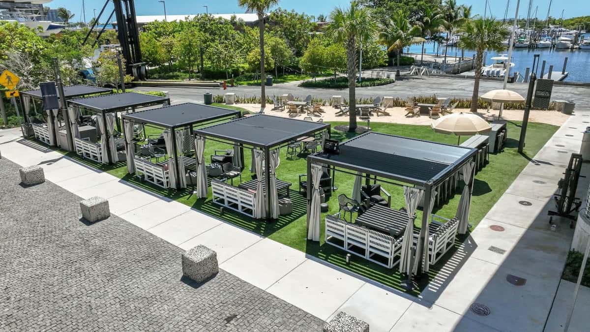 Aerial view of Bayshore Club cabanas and outdoor seating zones beside the marina.
