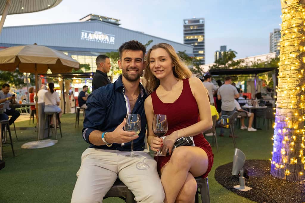 Couple enjoying wine together at an outdoor event with evening dining atmosphere