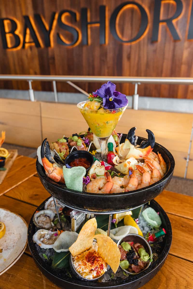 Fine-dining seafood spread with grilled fish, lobster, champagne, and a tiered shellfish platter at Bayshore.