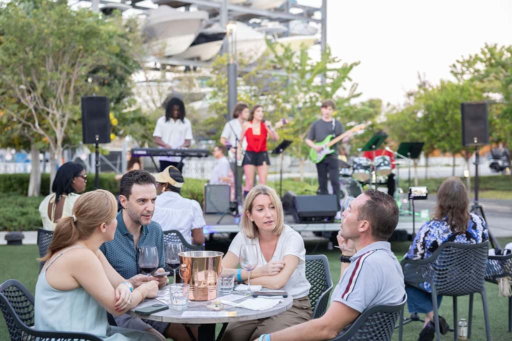 Guests enjoying a private outdoor dining event with wine and live music in the background